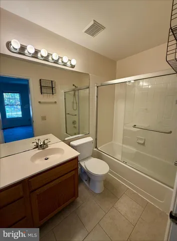 a spacious bathroom with a bathtub shower sink mirror vanity and toilet