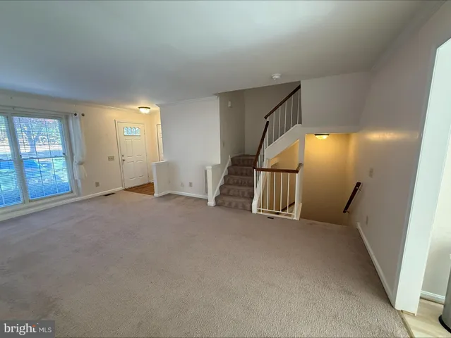 an empty room with windows and stairs