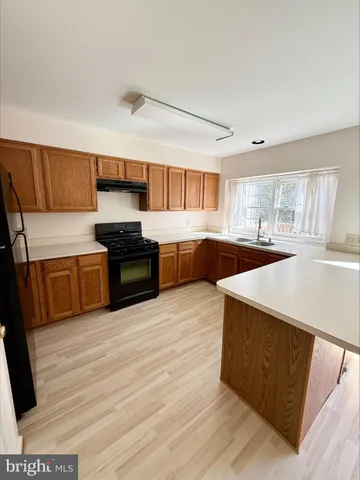 a kitchen with stainless steel appliances a stove a sink and a refrigerator