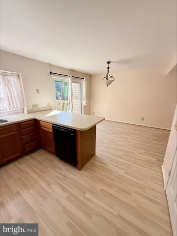 a living room with hard wood floors and a kitchen view