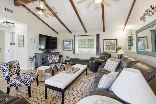 a living room with furniture a flat screen tv and a large window