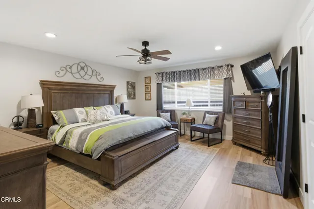 a bedroom with a bed and painting on the wall