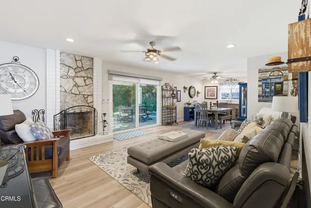 a living room with furniture fireplace and a large window