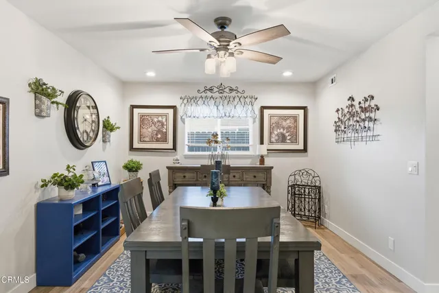 a view of a dining room with furniture a chandelier and a window