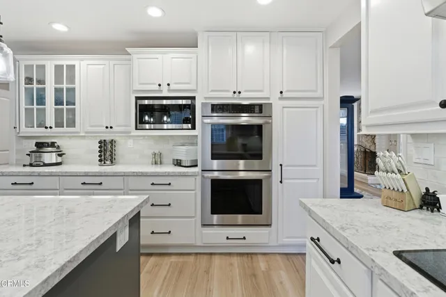 a kitchen with stainless steel appliances granite countertop a stove microwave and cabinets