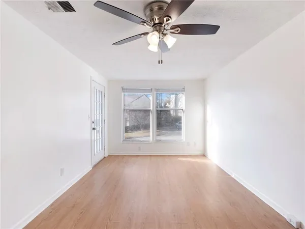 a view of wooden floor and a chandelier fan in a room
