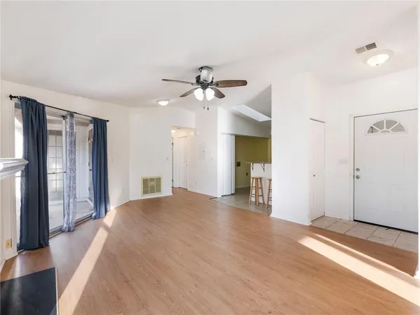 a view of a livingroom with a chandelier fan and wooden floor