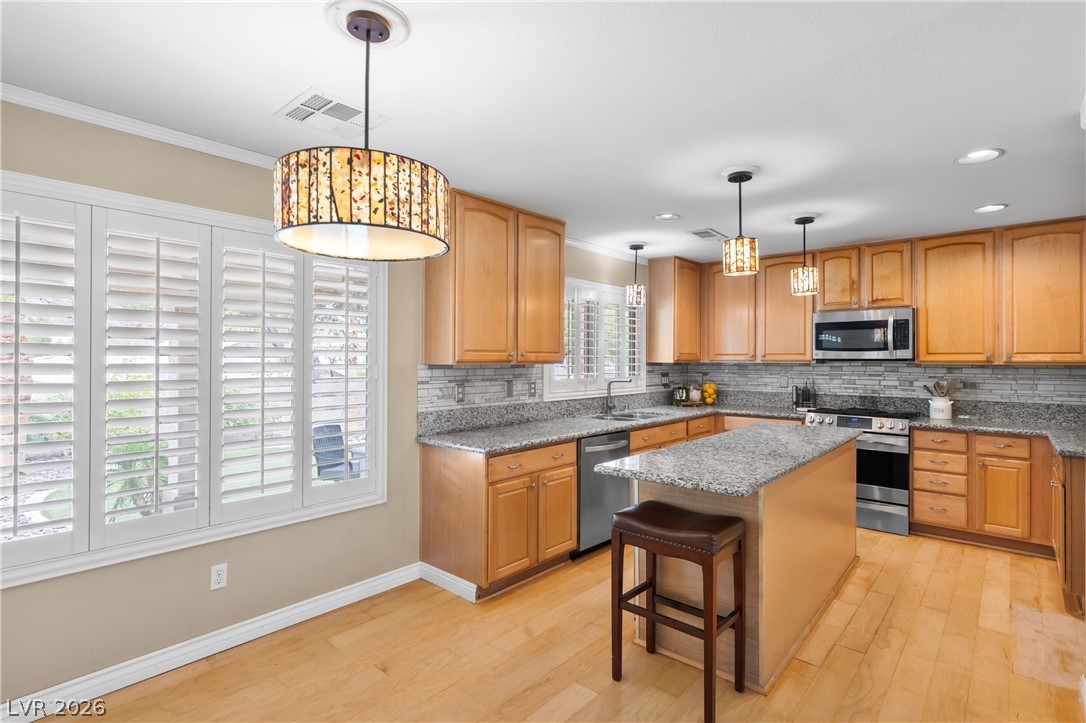 708 Vortex Avenue Henderson, NV 89002 - Photo 12 of 71 Culinary creations come alive in this kitchen, featuring light wood cabinetry and granite countertops.