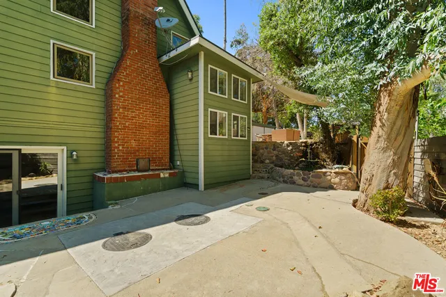 a view of a house with a yard and plant fire pit