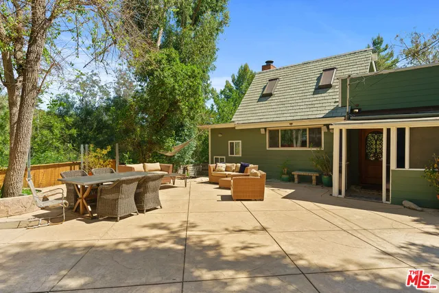 a view of a house with backyard and sitting area