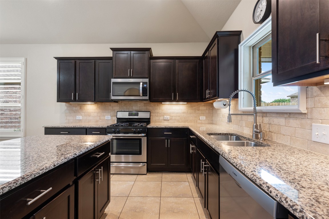 533 Flag Lane Leander, TX 78641 - Photo 12 of 40 Kitchen sink has a spring sprayer faucet with Bosch dishwasher, and lofted ceiling.