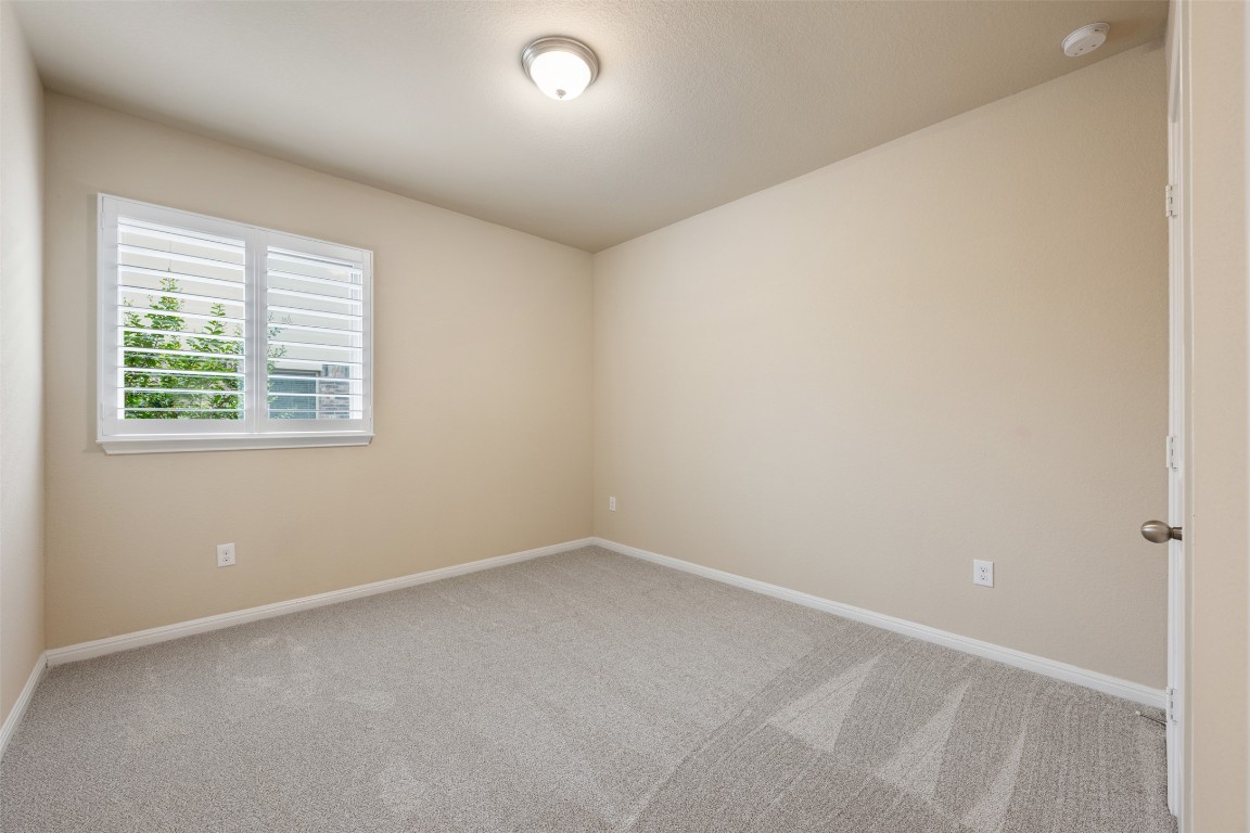 533 Flag Lane Leander, TX 78641 - Photo 19 of 40 Secondary downstairs bedroom 2 with newly installed carpet and plantation shutters.