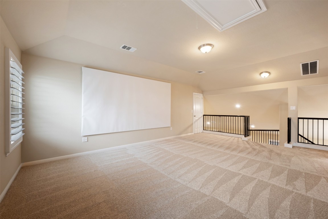 533 Flag Lane Leander, TX 78641 - Photo 29 of 40 Carpeted spare room with lofted ceiling, attic access, and baseboards