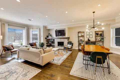a living room with furniture a fireplace a flat screen tv and couches