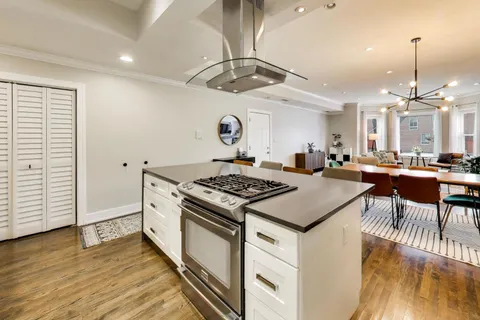 a kitchen with stainless steel appliances granite countertop a stove and a wooden floors