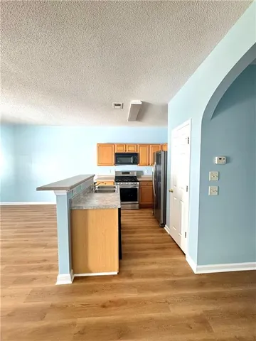 a view of kitchen with kitchen island stainless steel appliances counter space