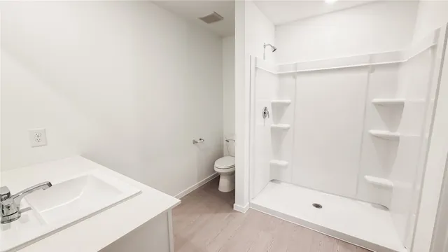 a bathroom with a granite countertop sink toilet and shower
