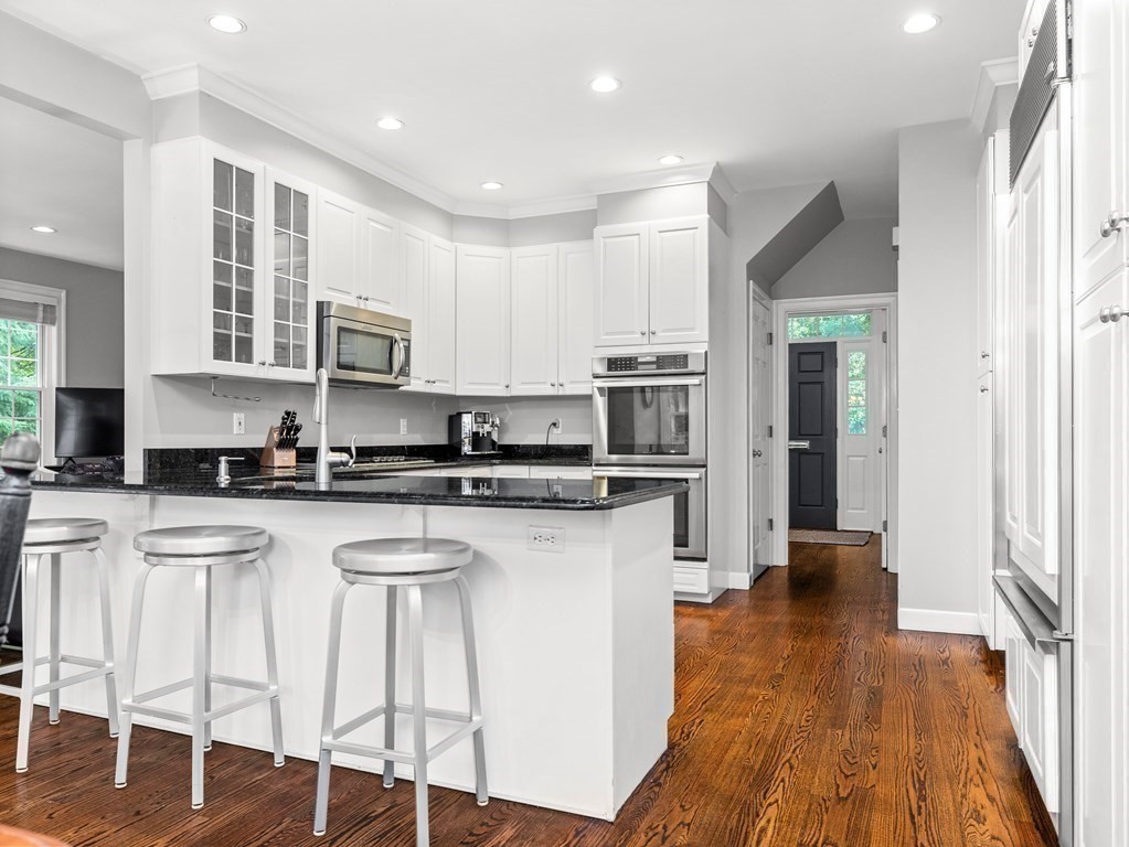 34 Upwey Road Wellesley, MA 02481 - Photo 7 of 19 a kitchen with stainless steel appliances granite countertop a refrigerator a stove top oven and a sink with wooden floor