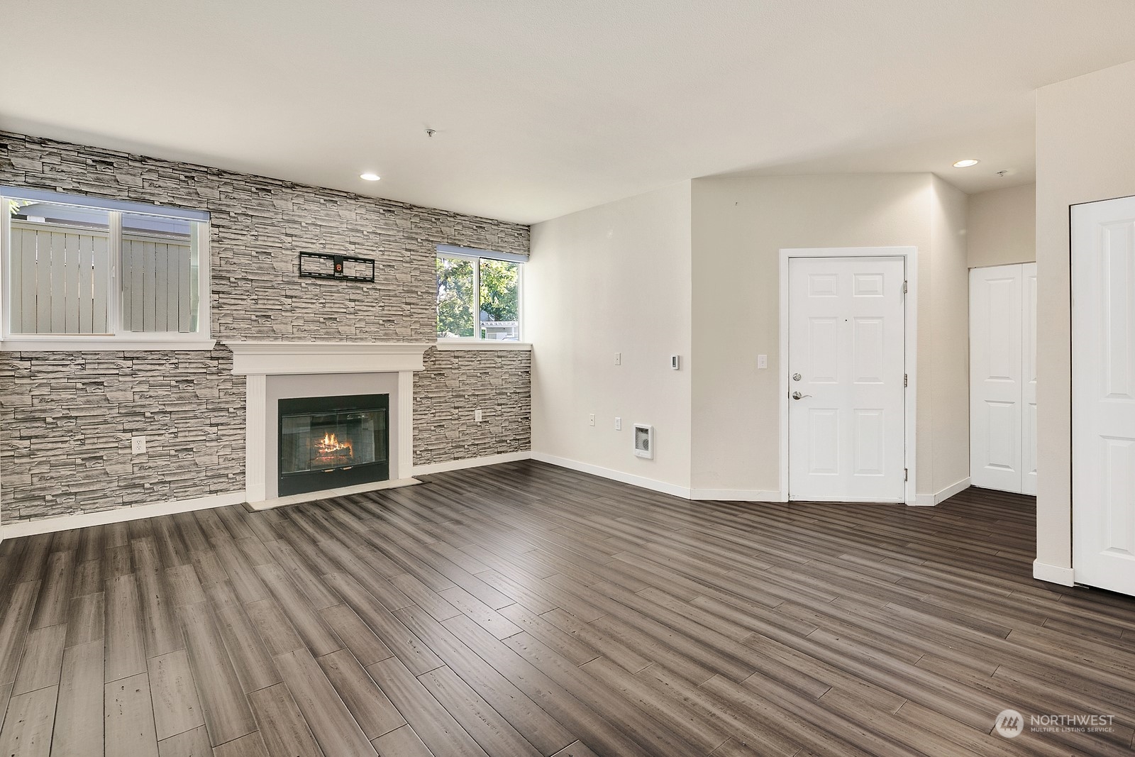 3901 243rd Place Southeast, Unit O104 Bothell, WA 98021 - Photo 10 of 26 a view of empty room with wooden floor and fireplace