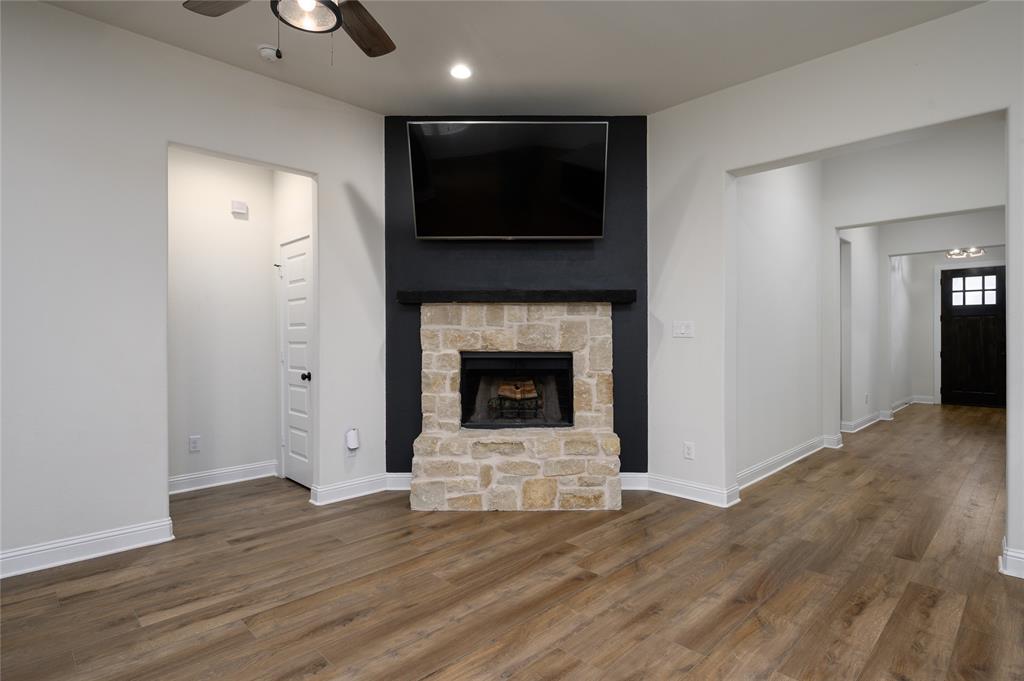 300 Bronco Drive Pilot Point, TX 76258 - Photo 17 of 31 a view of an empty room with wooden floor and a fireplace