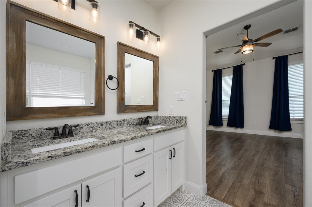 300 Bronco Drive Pilot Point, TX 76258 - Photo 21 of 31 a bathroom with a granite countertop sink vanity and mirror