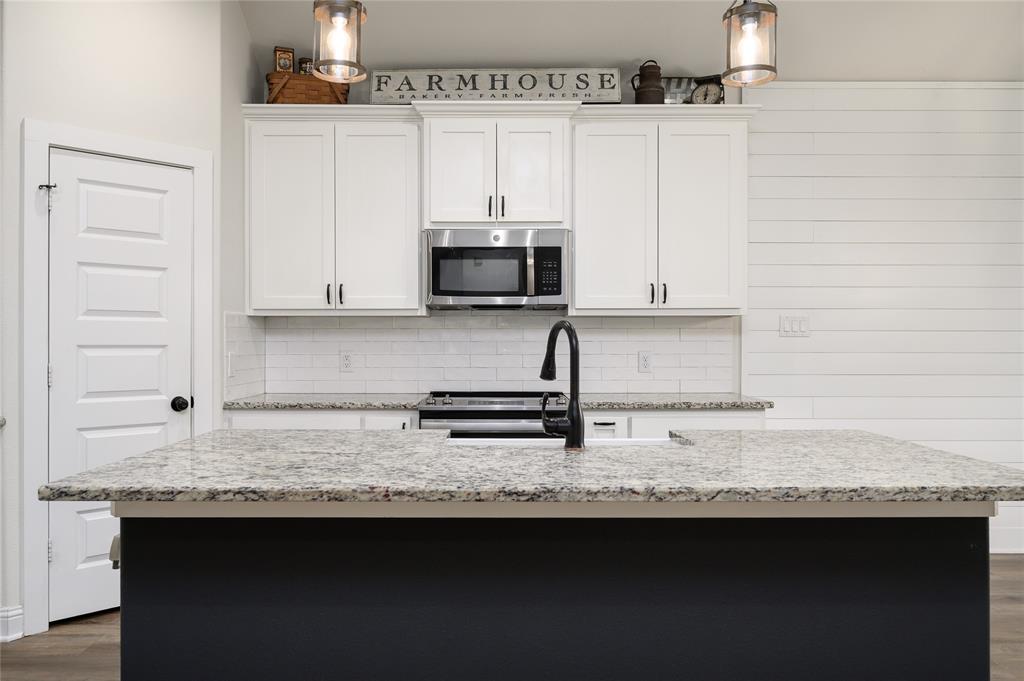 300 Bronco Drive Pilot Point, TX 76258 - Photo 9 of 31 a kitchen with granite countertop a sink stainless steel appliances and cabinets