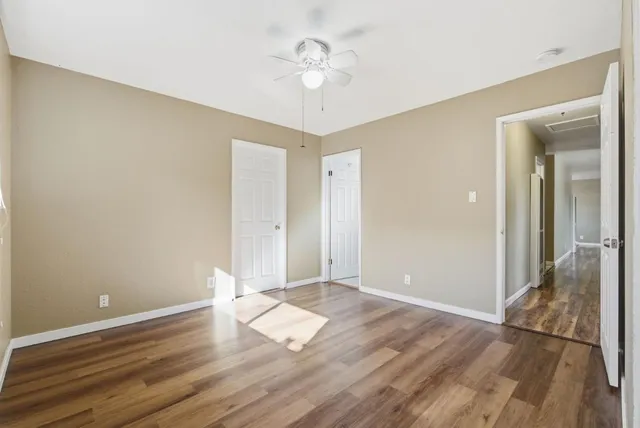 a view of empty room with wooden floor