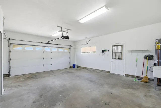 an empty room with ceiling fan and windows