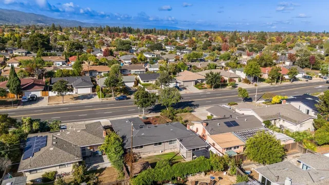 an aerial view of a house with a yard and large trees