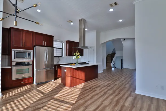 a front view of a building with lot of cars and trees