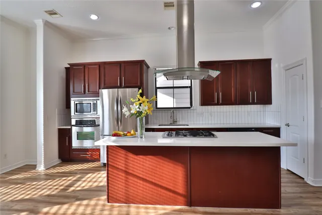 a kitchen with stainless steel appliances granite countertop wooden floors and sink