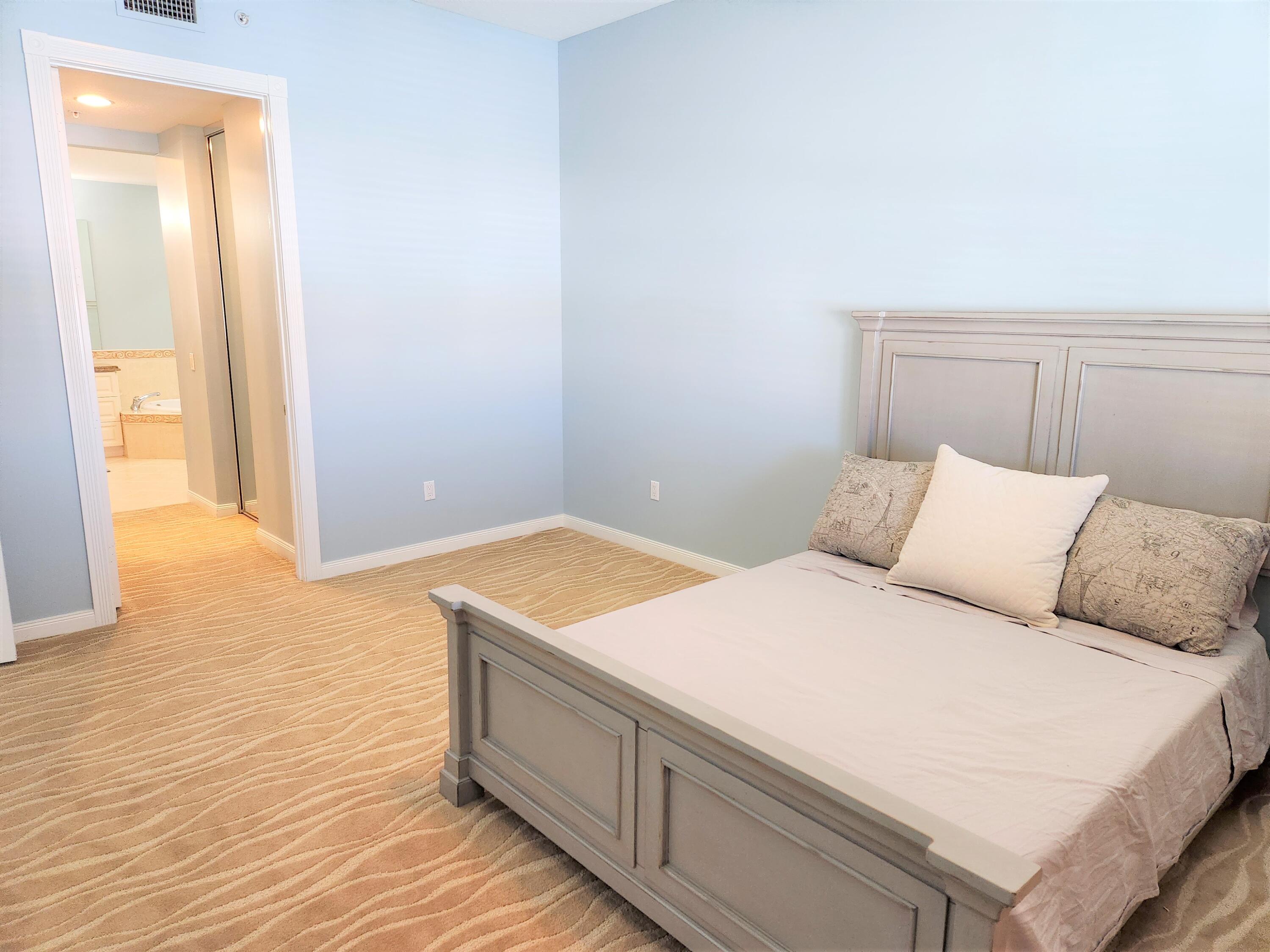 9 Harbour Isle Drive East, Unit PH5 Fort Pierce, FL 34949 - Photo 17 of 27 a bedroom with a bed and a painting on the wall