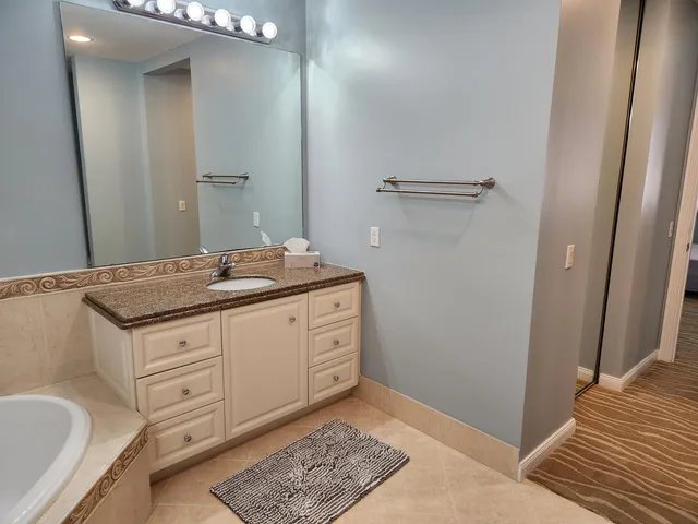a bathroom with a granite countertop sink and a mirror