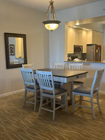 a dining room with furniture a chandelier and wooden floor