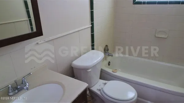 a white toilet and tub sitting next to a bathroom sink