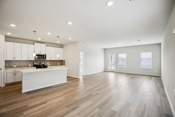 a view of kitchen with wooden floor and electronic appliances