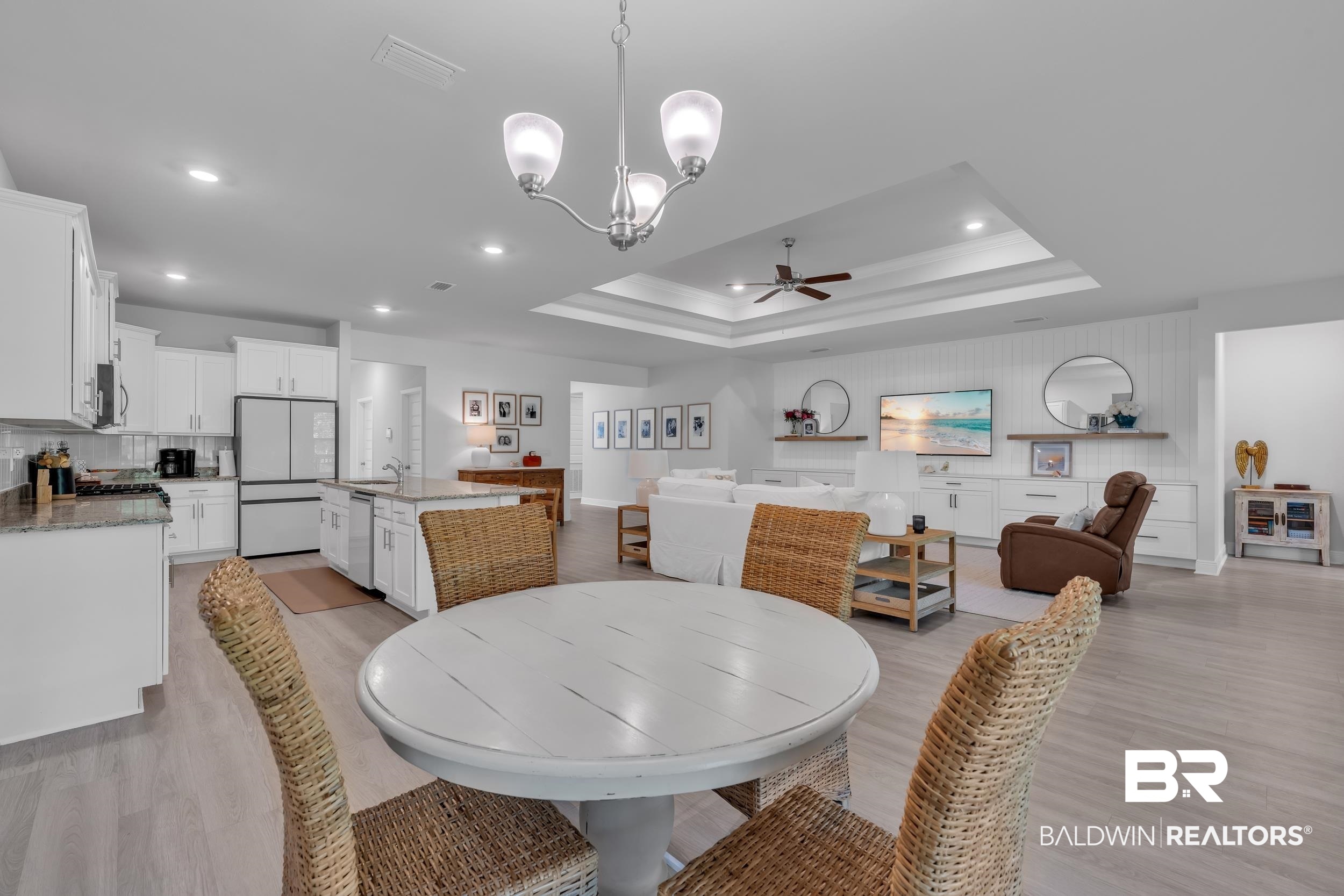 8774 Primland Boulevard Foley, AL 36535 - Photo 14 of 49 Dining area with light wood-type flooring, a raised ceiling, a ceiling fan, a chandelier, and recessed lighting