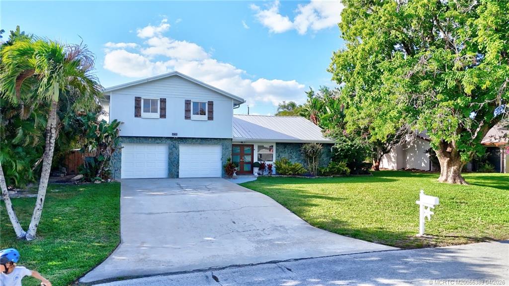 4729 Southeast Glen Ridge Trail Stuart, FL 34997 - Photo 1 of 81 a front view of a house with garden