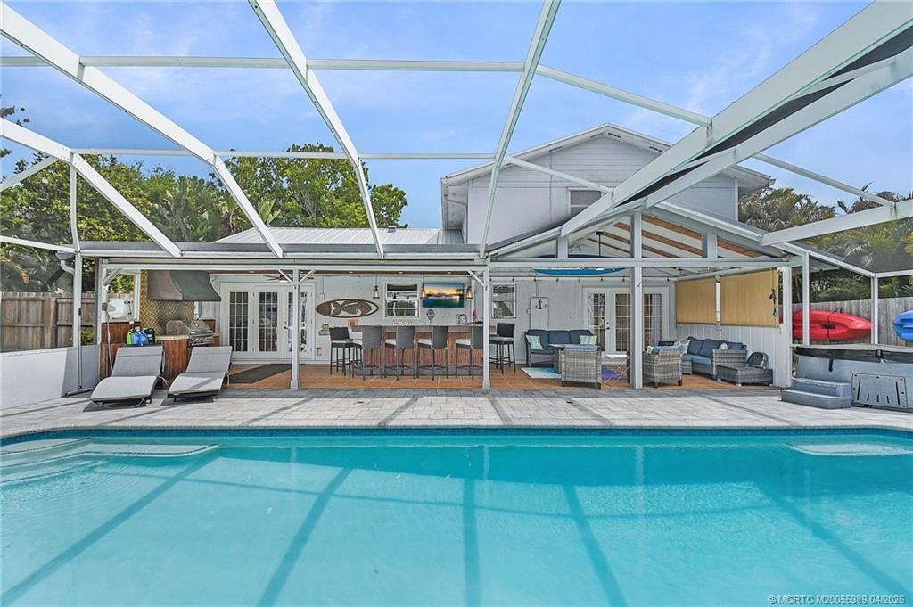 4729 Southeast Glen Ridge Trail Stuart, FL 34997 - Photo 20 of 81 a view of a patio with table and chairs under an umbrella