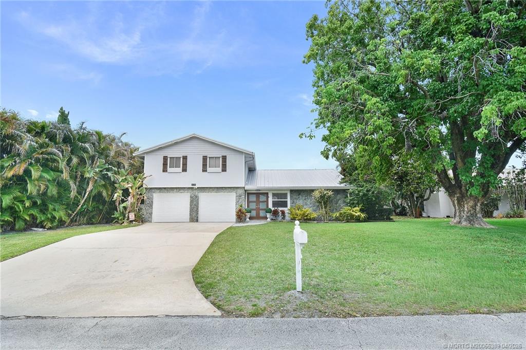 4729 Southeast Glen Ridge Trail Stuart, FL 34997 - Photo 2 of 81 a view of house with a big yard and large trees