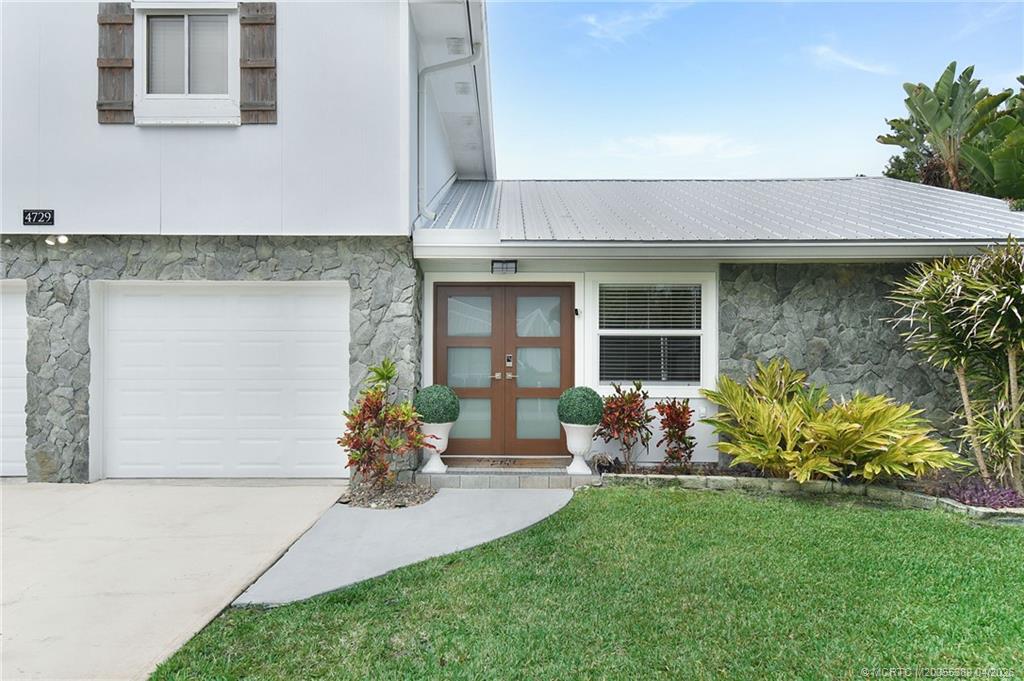 4729 Southeast Glen Ridge Trail Stuart, FL 34997 - Photo 3 of 81 a front view of a house with garden