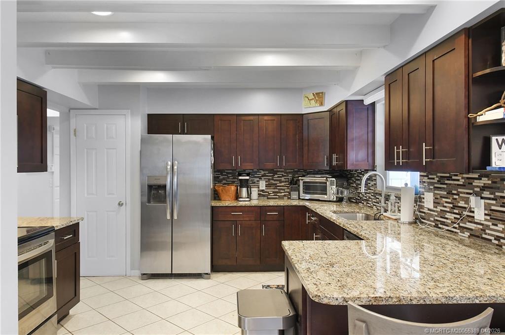 4729 Southeast Glen Ridge Trail Stuart, FL 34997 - Photo 39 of 81 a kitchen with stainless steel appliances granite countertop a sink a stove a refrigerator a washer and dryer
