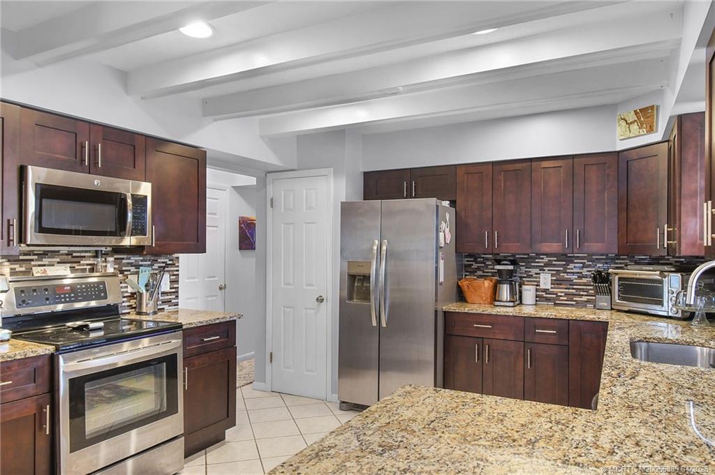 4729 Southeast Glen Ridge Trail Stuart, FL 34997 - Photo 40 of 81 a kitchen with stainless steel appliances granite countertop a stove refrigerator and microwave
