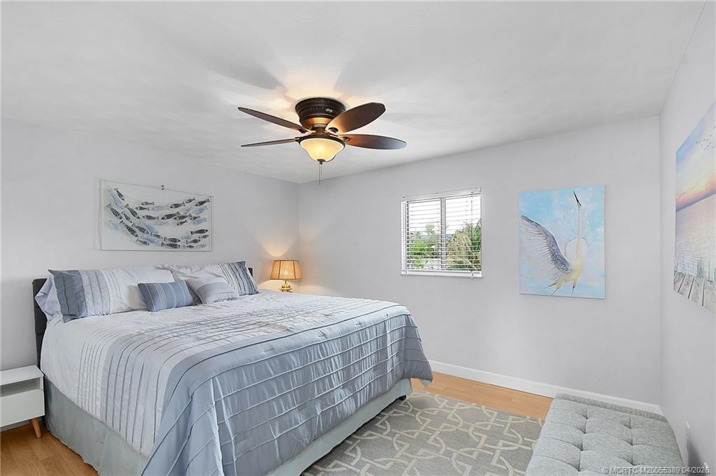 4729 Southeast Glen Ridge Trail Stuart, FL 34997 - Photo 50 of 81 a bedroom with a large bed and a chandelier