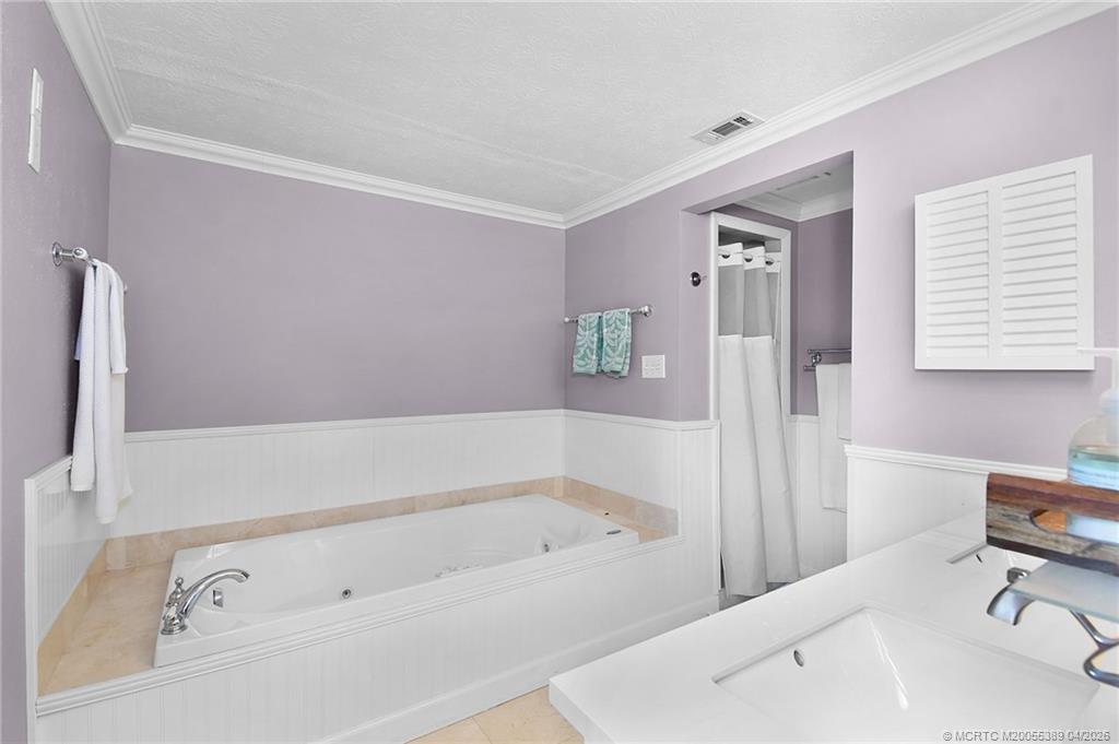 4729 Southeast Glen Ridge Trail Stuart, FL 34997 - Photo 56 of 81 a bathroom with a bathtub and a sink