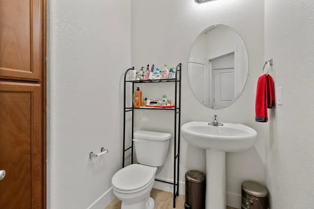 a bathroom with a sink toilet and a mirror