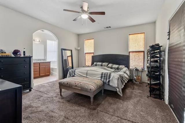 a spacious bedroom with a bed and a chandelier