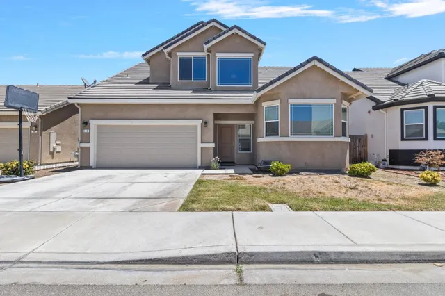a front view of a house with garage and parking