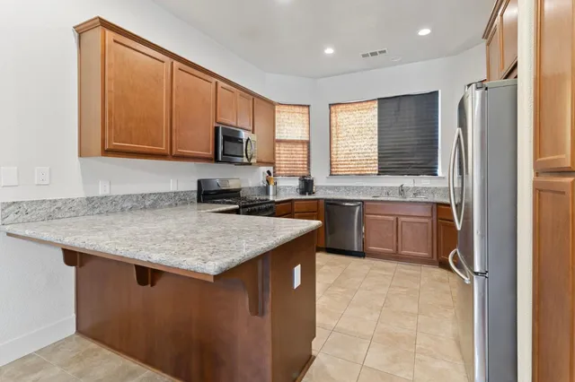 a kitchen with stainless steel appliances granite countertop a sink stove and refrigerator