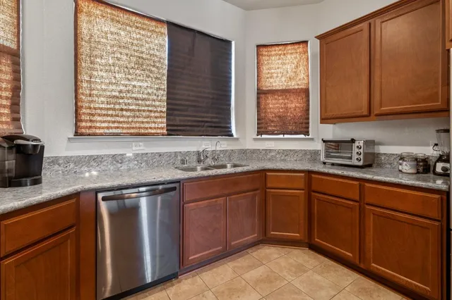 a kitchen with stainless steel appliances granite countertop wooden cabinets a sink and a window